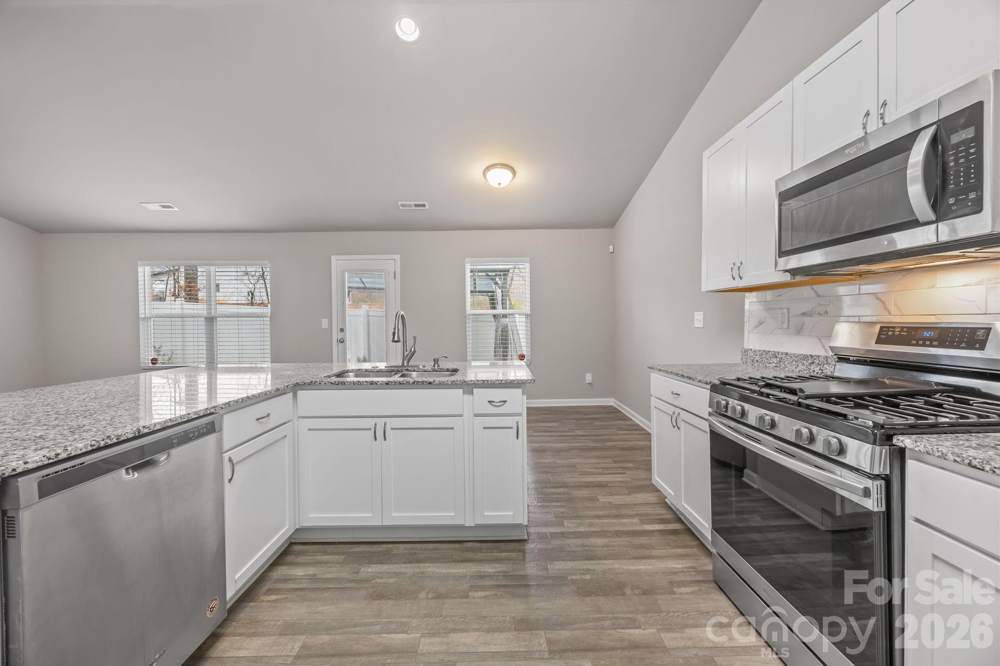 1219 Amberlight Circle Salisbury, NC 28144 - Photo 18 of 30 a kitchen with stainless steel appliances granite countertop a stove and a sink