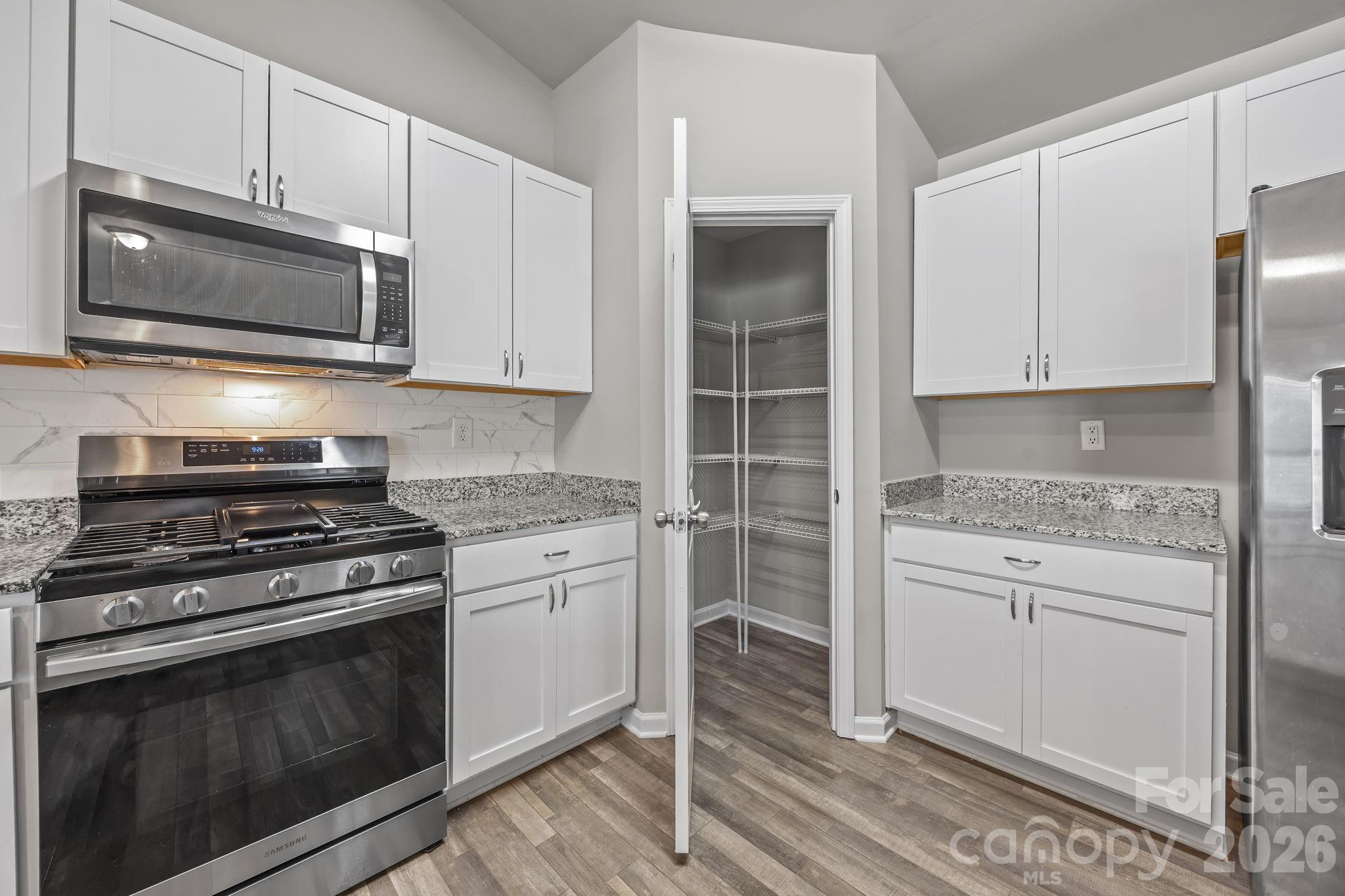 1219 Amberlight Circle Salisbury, NC 28144 - Photo 19 of 30 a kitchen with stainless steel appliances granite countertop a stove and a microwave