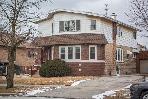 a front view of a house with yard and parking