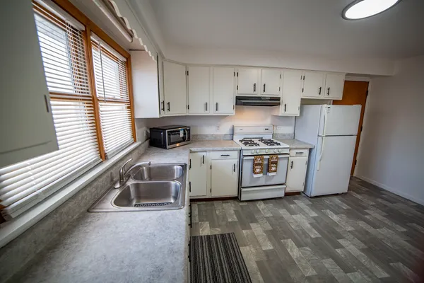 a kitchen with stainless steel appliances granite countertop a stove a sink and a refrigerator