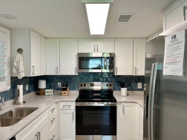 a kitchen with a sink a stove and cabinets
