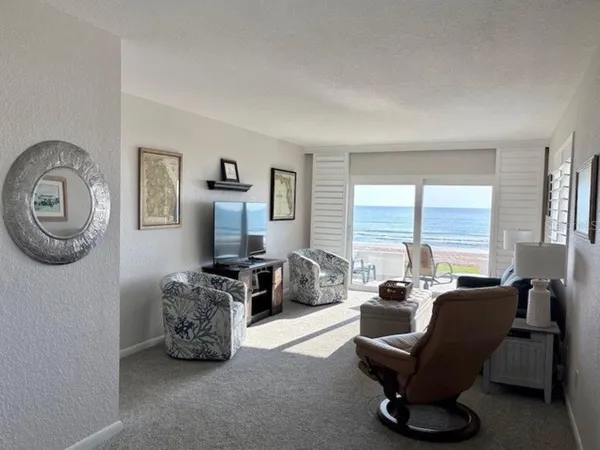 a living room with furniture a large window and a flat screen tv