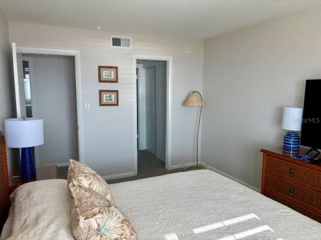 a bedroom with a bed and a flat tv screen on the table