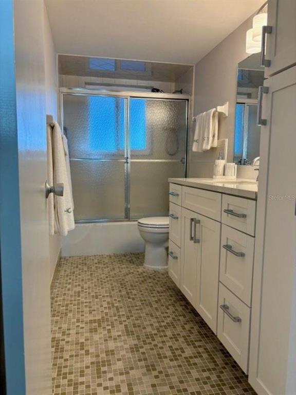 815 Ocean Shore Boulevard, Unit 13 Ormond Beach, FL 32176 - Photo 14 of 17 a bathroom with a granite countertop sink a toilet and a shower