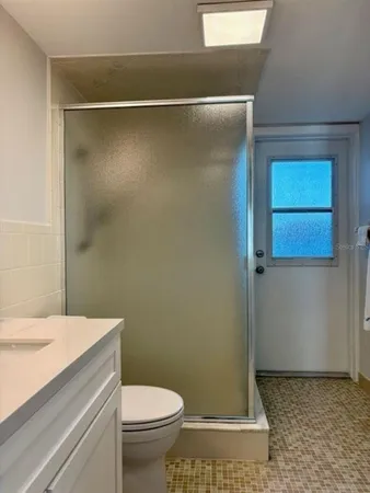 a bathroom with a sink a toilet and shower