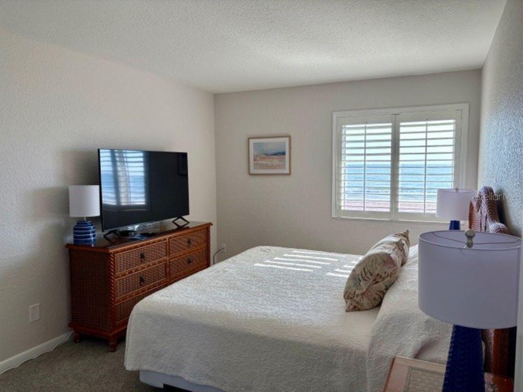 815 Ocean Shore Boulevard, Unit 13 Ormond Beach, FL 32176 - Photo 3 of 17 a bedroom with a bed and a flat screen tv