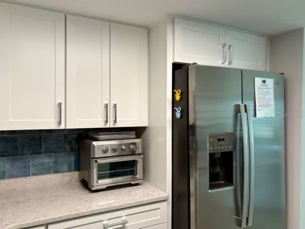 a kitchen with granite countertop a refrigerator and a stove