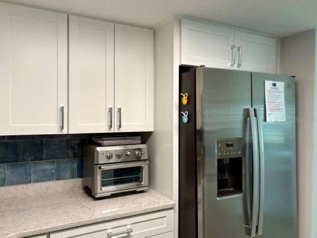 a kitchen with granite countertop a refrigerator and a stove