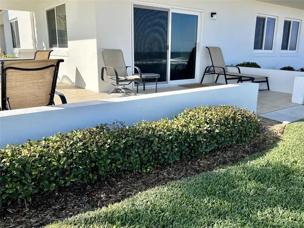 a view of two chairs and table in a patio