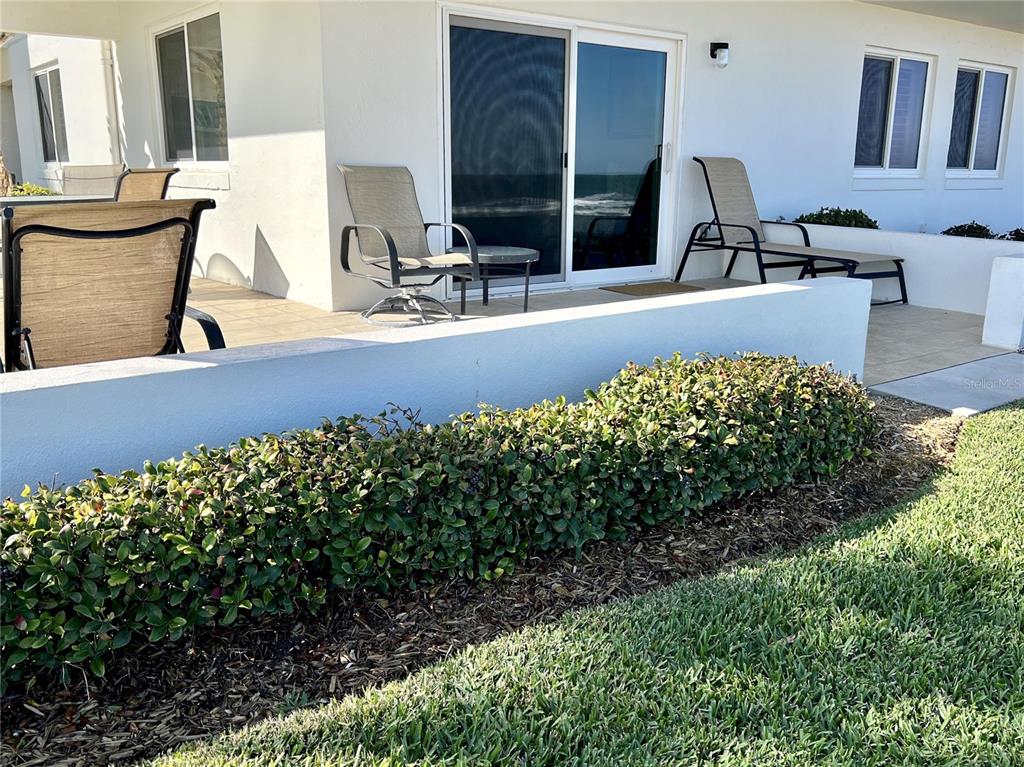 815 Ocean Shore Boulevard, Unit 13 Ormond Beach, FL 32176 - Photo 5 of 17 a view of two chairs and table in a patio