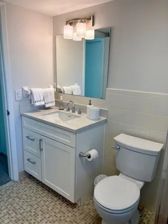 a bathroom with a toilet a sink and mirror
