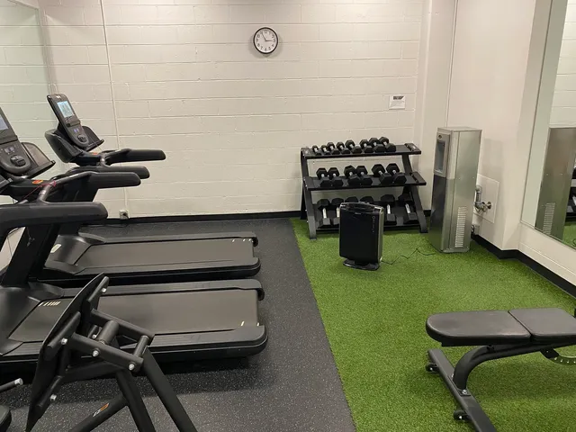 a room with gym equipment and large mirror