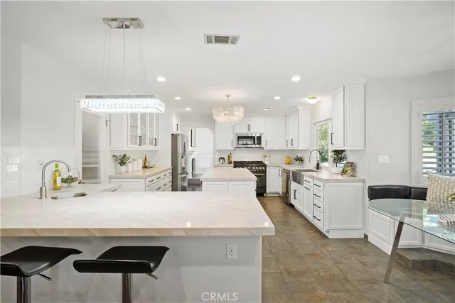 a large white kitchen with a sink and cabinets