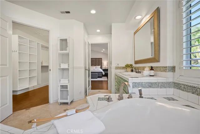 a spacious bathroom with a granite countertop sink a mirror and shower