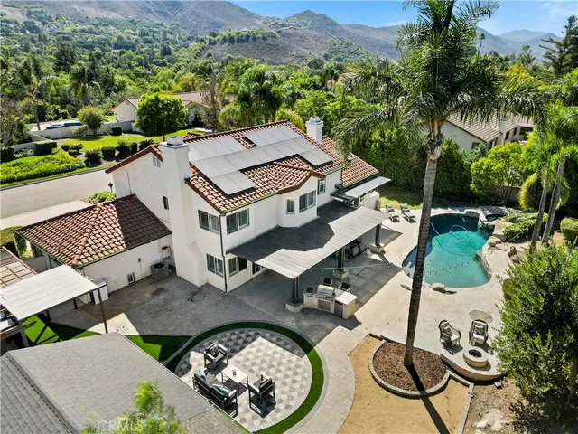 an aerial view of a house with swimming pool and mountain view