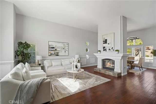 a living room with furniture a fireplace and wooden floor
