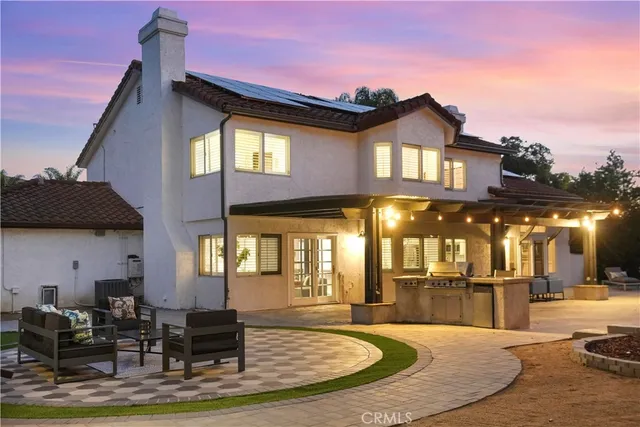 a front view of a house with a yard and potted plants