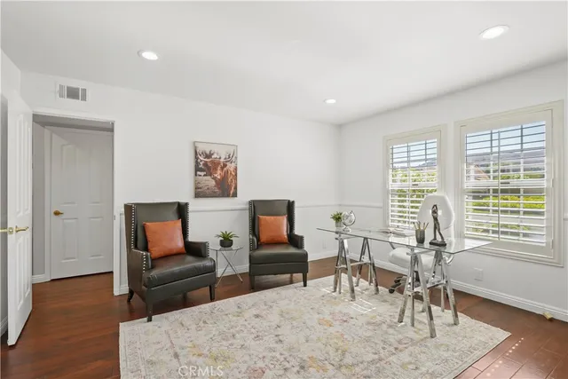 a living room with furniture and a flat screen tv with wooden floor