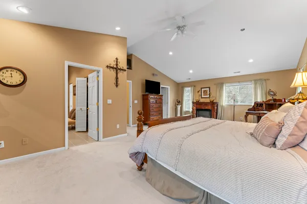 a spacious bedroom with a large bed and a chandelier