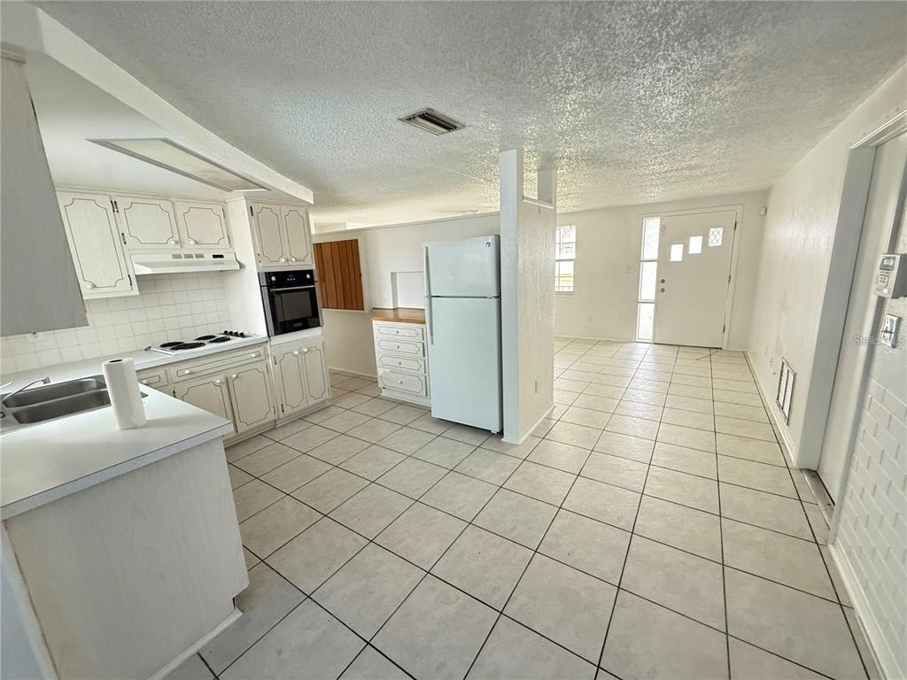4233 Darlington Road Holiday, FL 34691 - Photo 18 of 25 a kitchen with stainless steel appliances a refrigerator sink and cabinets