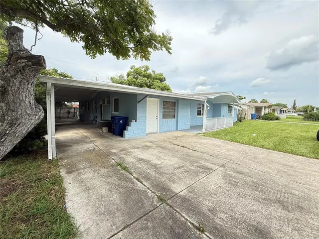 a view of a house with a patio and a yard