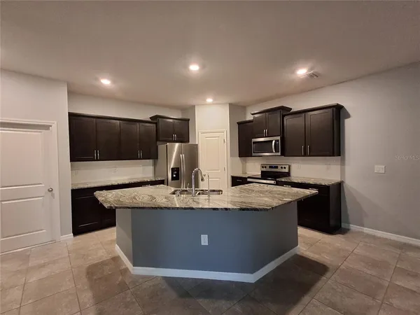 a kitchen with kitchen island granite countertop stainless steel appliances and cabinets