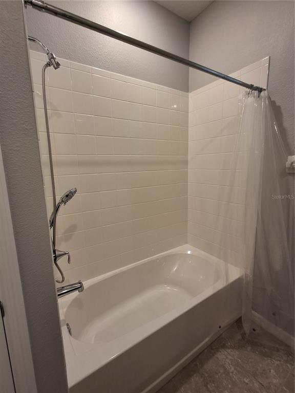 7891 Stonebrook Circle Wesley Chapel, FL 33545 - Photo 25 of 39 a bathroom with a bathtub and a shower