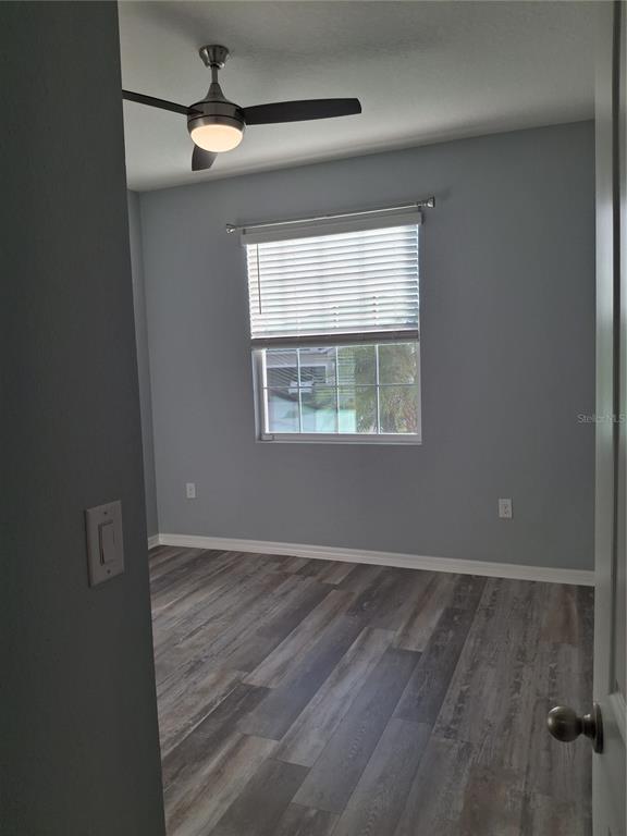 7891 Stonebrook Circle Wesley Chapel, FL 33545 - Photo 27 of 39 an empty room with wooden floor fan and windows