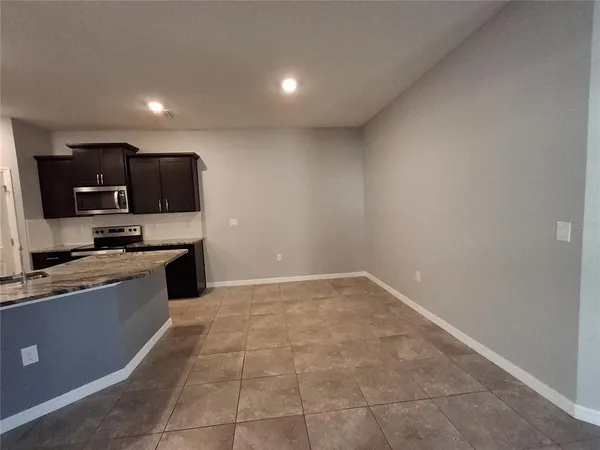 a view of kitchen with stainless steel appliances granite countertop counter top and stove