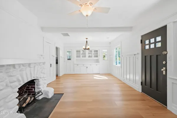 a view of a livingroom with a fireplace cabinets and a ceiling fan