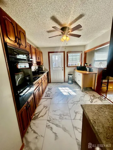 a kitchen with stainless steel appliances kitchen island granite countertop a stove top oven a sink dishwasher and cabinets