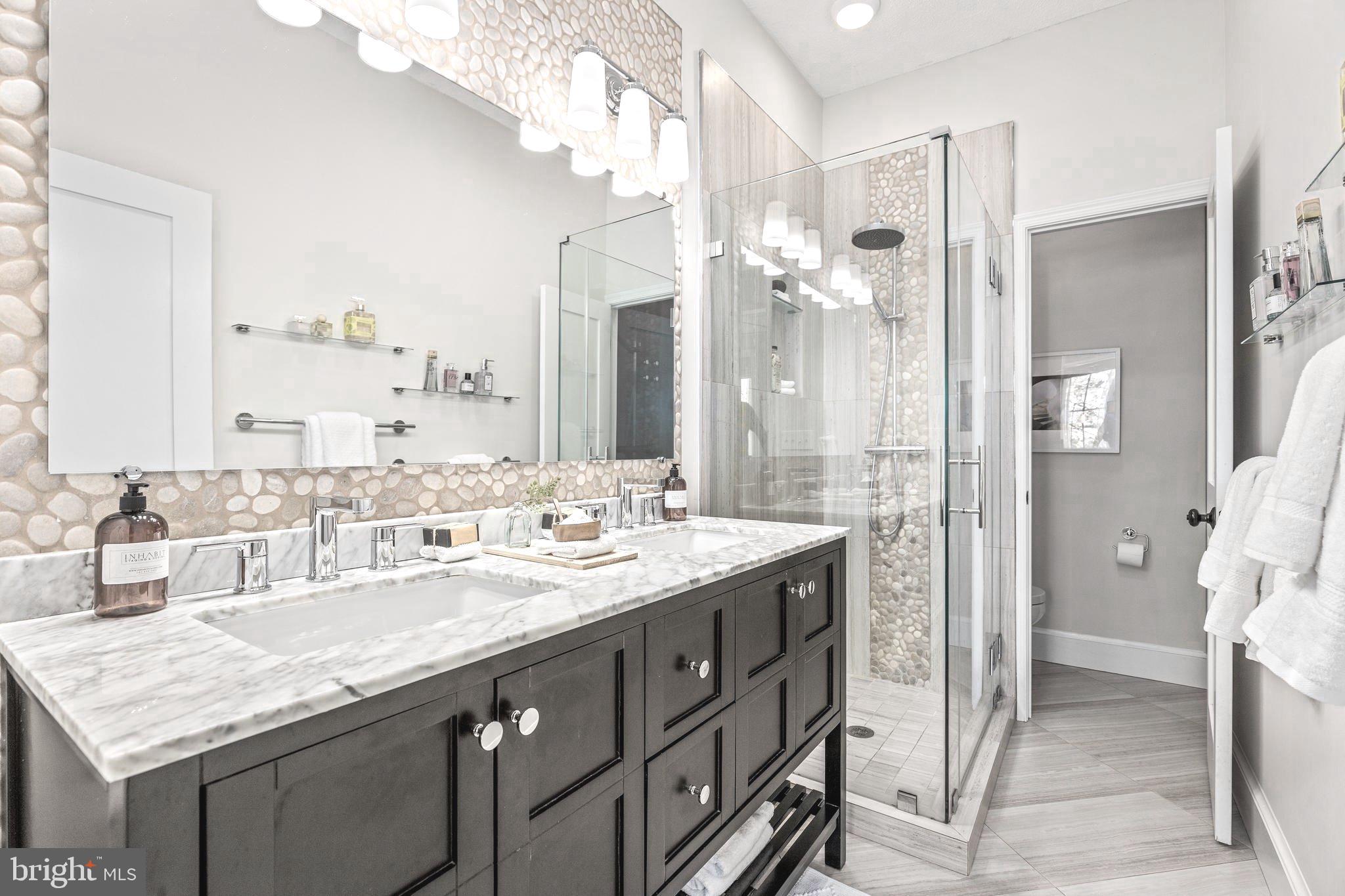 1213 29th Street Northwest Washington, DC 20007 - Photo 15 of 31 a bathroom with a granite countertop sink a large mirror and a shower