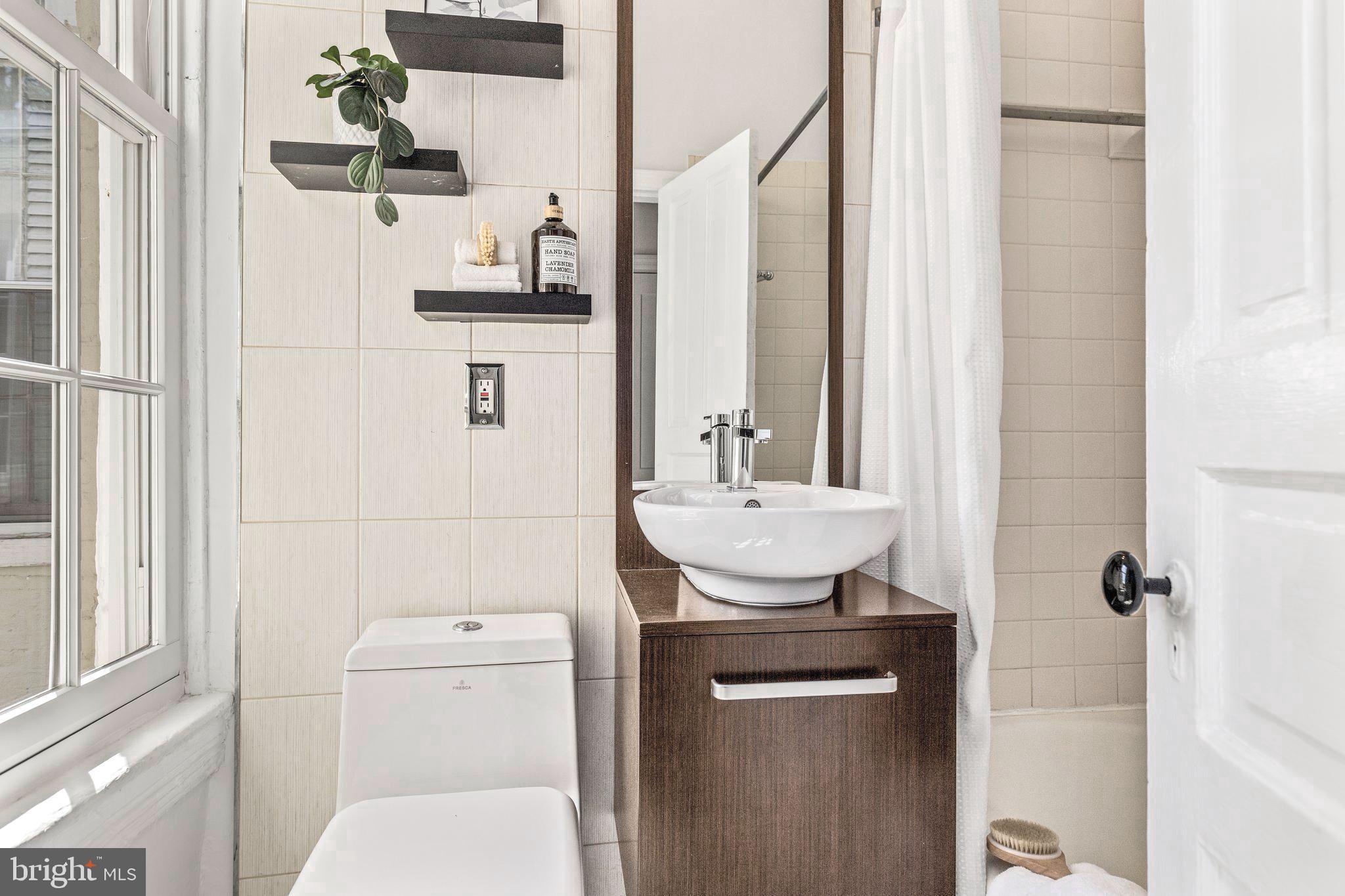1213 29th Street Northwest Washington, DC 20007 - Photo 19 of 31 a bathroom with a sink toilet and shower