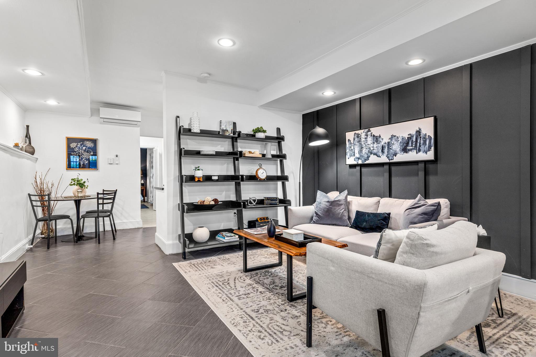 1213 29th Street Northwest Washington, DC 20007 - Photo 20 of 31 a living room with furniture a rug and wall paintings