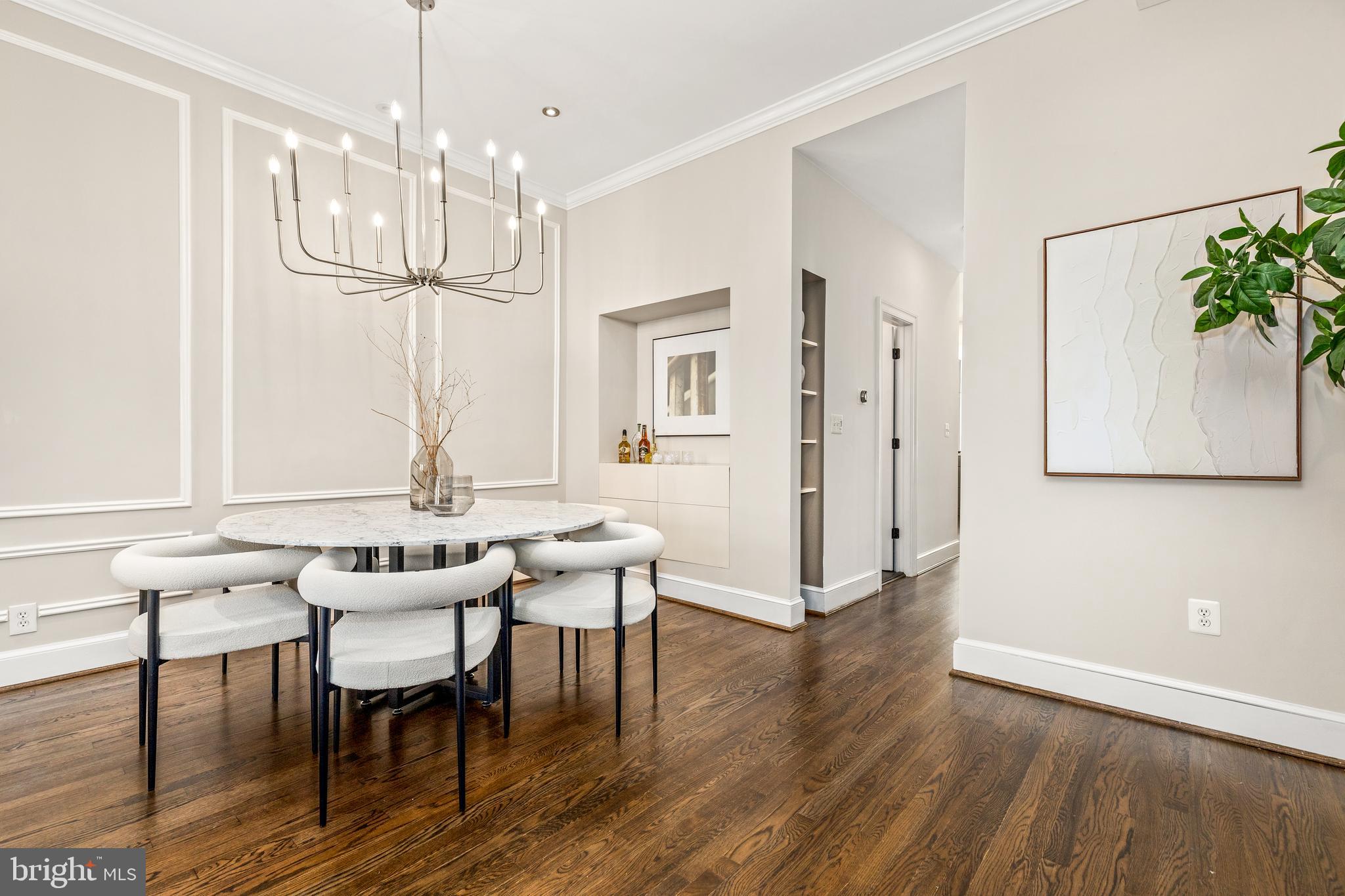1213 29th Street Northwest Washington, DC 20007 - Photo 6 of 31 a dining room with wooden floor a chandelier a wooden table and chairs