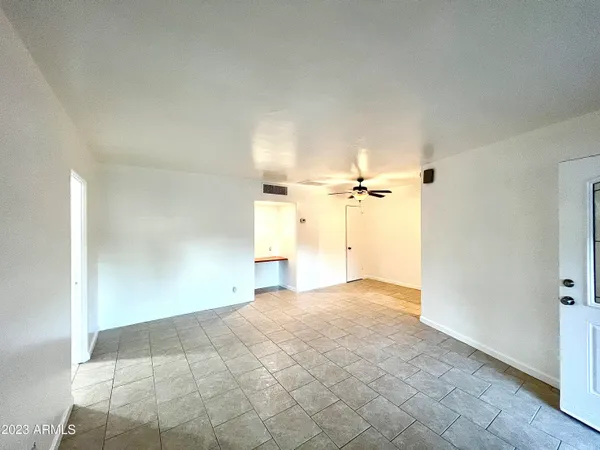 a view of a big room with a chandelier fan and windows