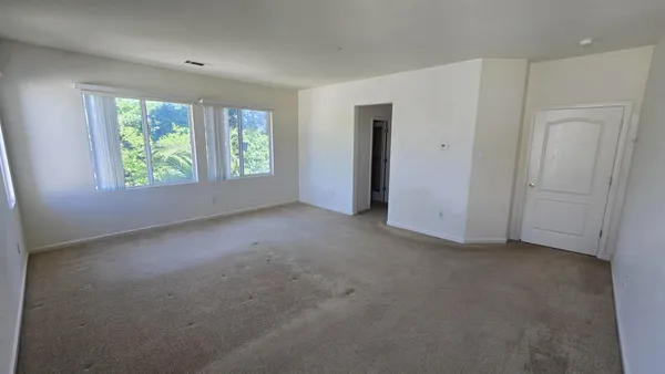 an empty room with windows and closet