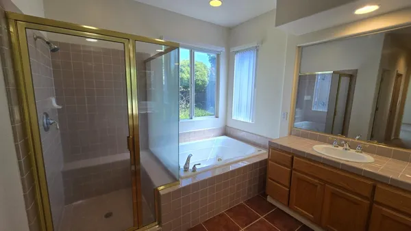 a bathroom with a tub shower and sink