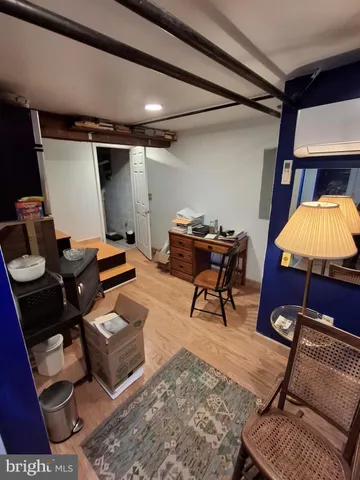 a living room with furniture a rug and a desk