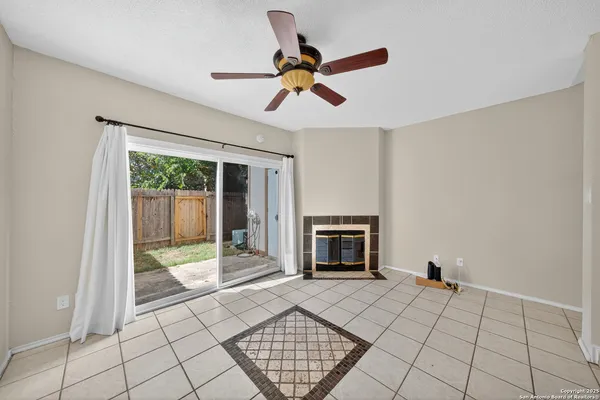 a view of an empty room with a fireplace and a window