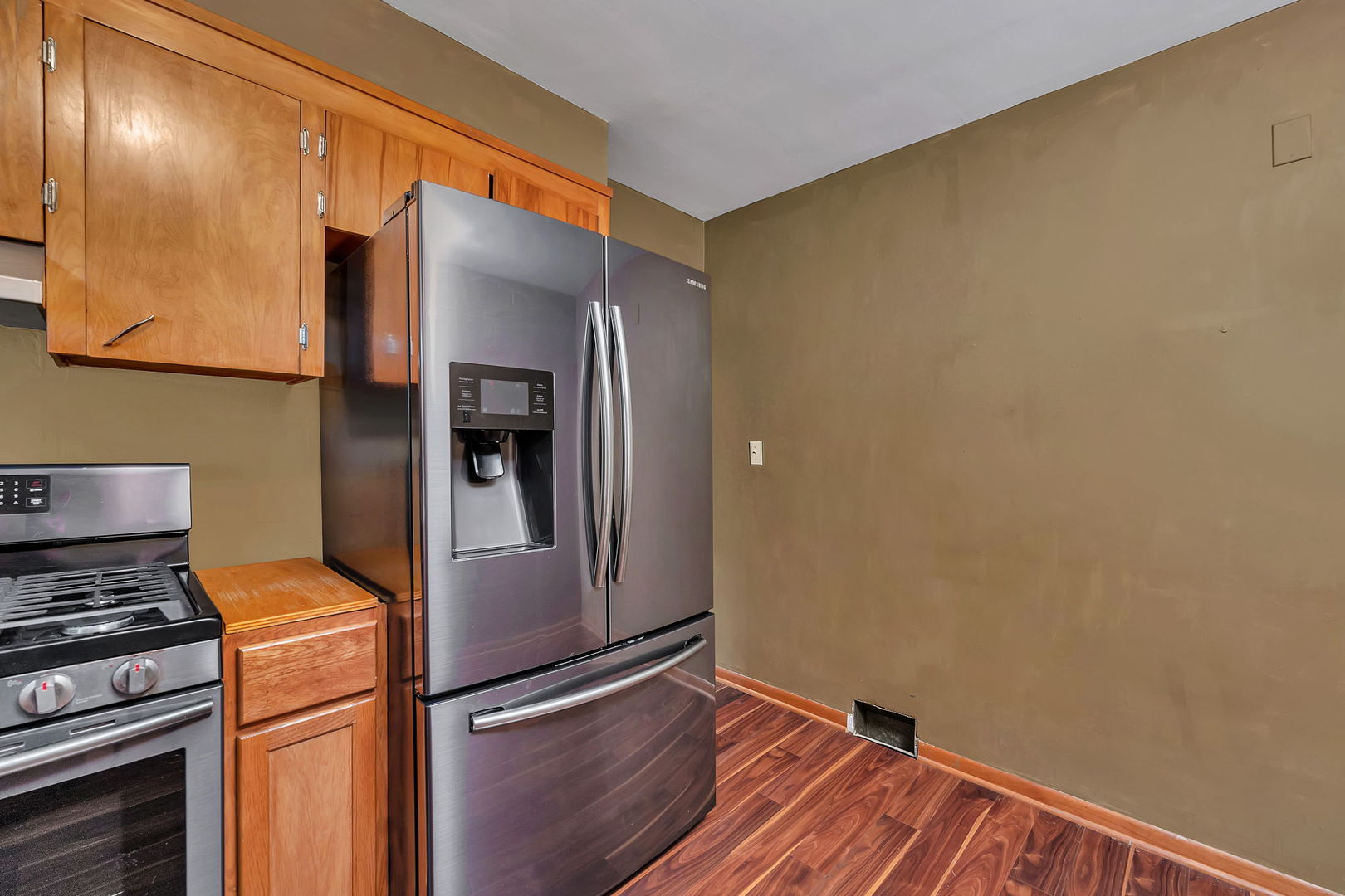 536 Fort Street Ottawa, IL 61350 - Photo 12 of 30 a view of a refrigerator in kitchen and an empty room with wooden floor