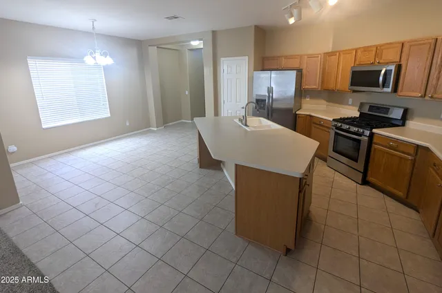 a kitchen with stainless steel appliances a sink a stove a microwave a counter top space and cabinets