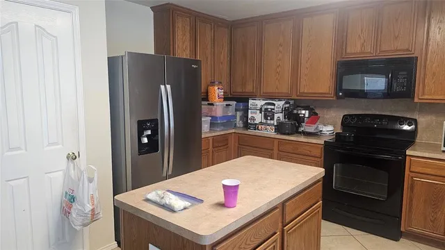 a kitchen with a sink dishwasher stove and refrigerator with wooden cabinet