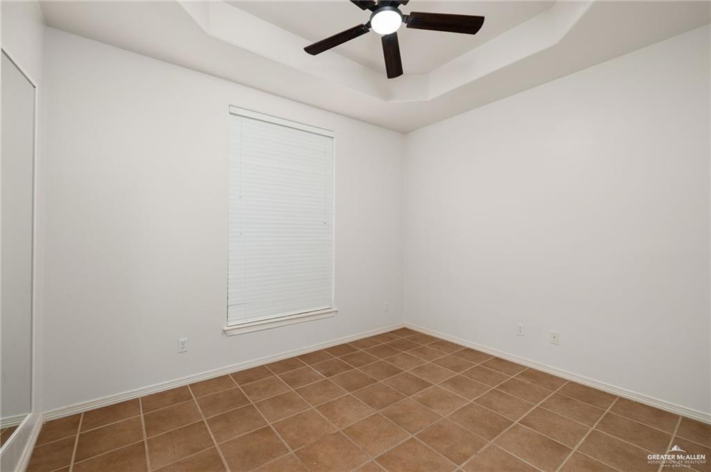 1311 East 28th Street Mission, TX 78574 - Photo 14 of 19 an empty room with a ceiling fan and carpet