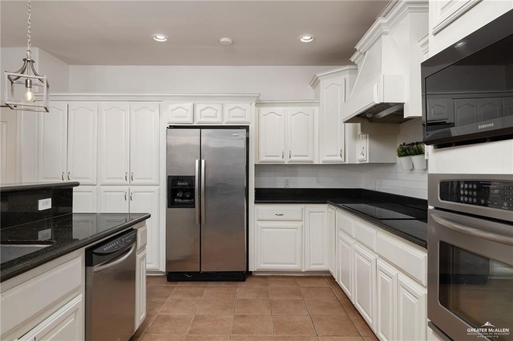 1311 East 28th Street Mission, TX 78574 - Photo 7 of 19 a kitchen with stainless steel appliances granite countertop a refrigerator a sink and white cabinets