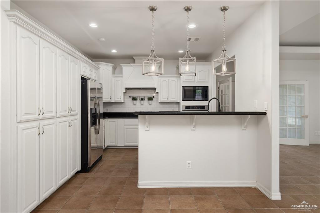 1311 East 28th Street Mission, TX 78574 - Photo 8 of 19 a kitchen with kitchen island a refrigerator sink and cabinets