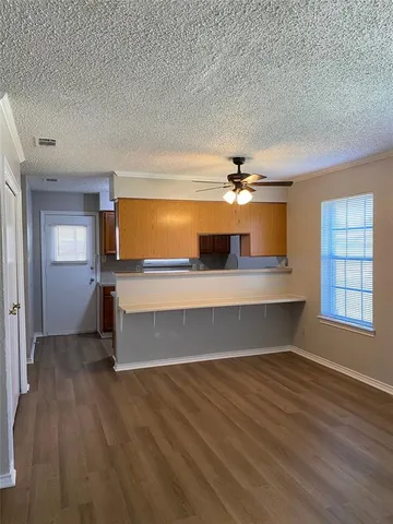 an empty room with wooden floor & windows and bathroom
