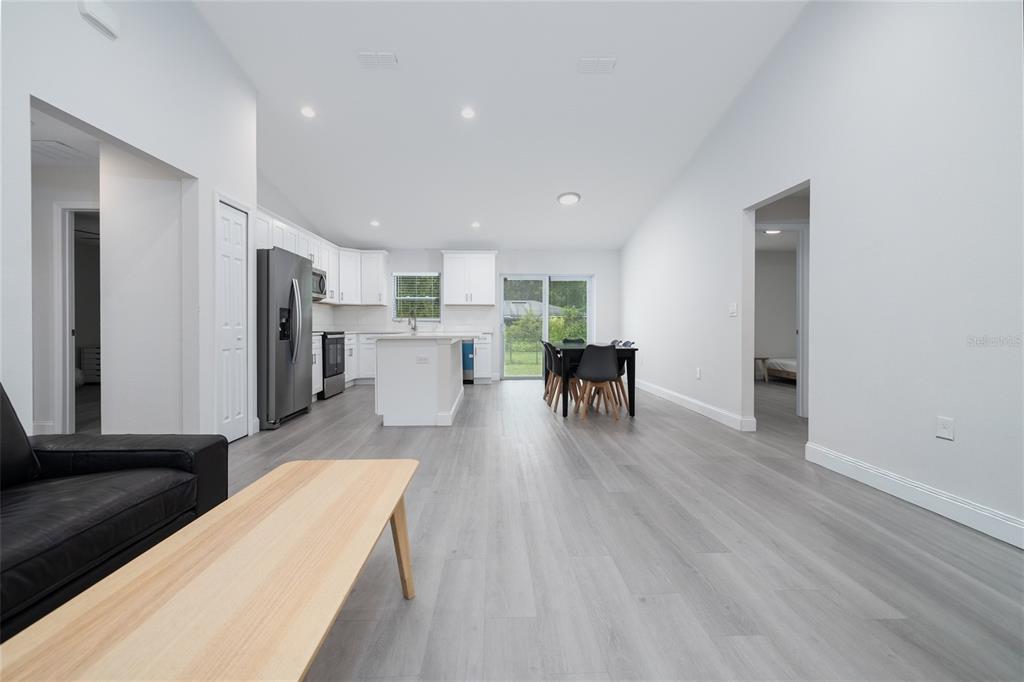 1171 9th Street Orange City, FL 32763 - Photo 11 of 27 a living room with stainless steel appliances kitchen island furniture and wooden floor