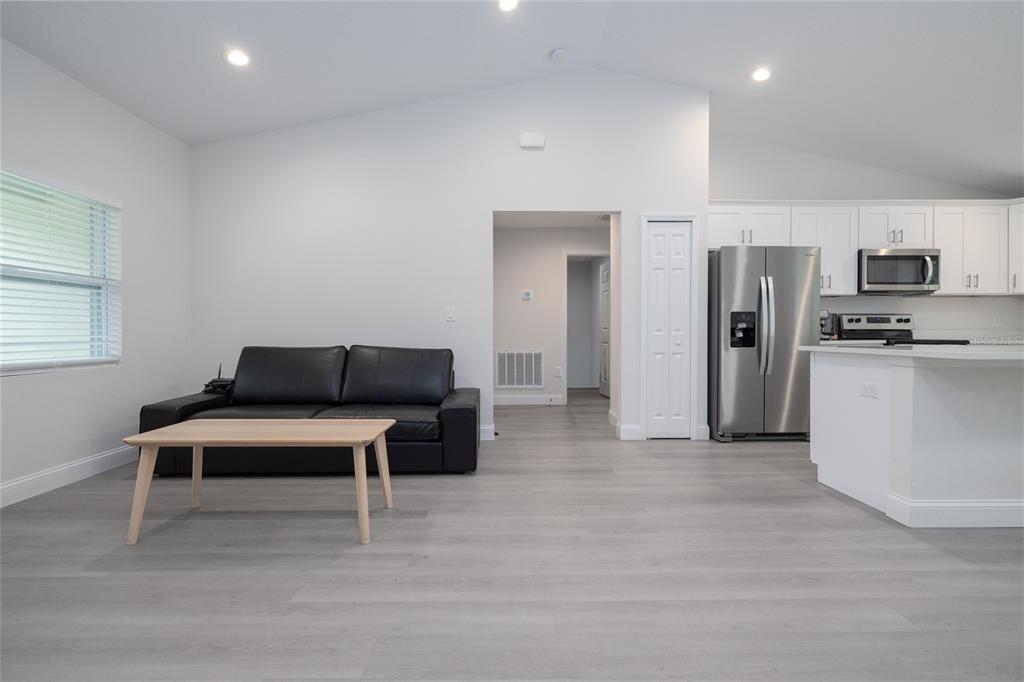 1171 9th Street Orange City, FL 32763 - Photo 13 of 27 a living room with stainless steel appliances kitchen island furniture and wooden floor