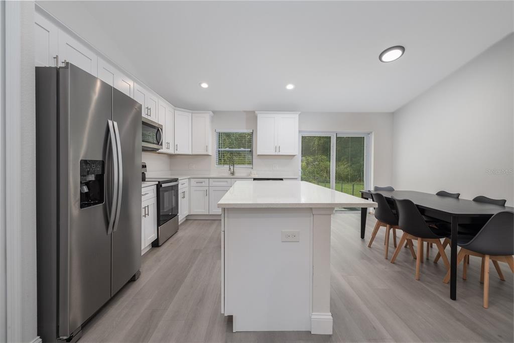 1171 9th Street Orange City, FL 32763 - Photo 14 of 27 a kitchen with kitchen island a counter top space a sink stainless steel appliances and cabinets
